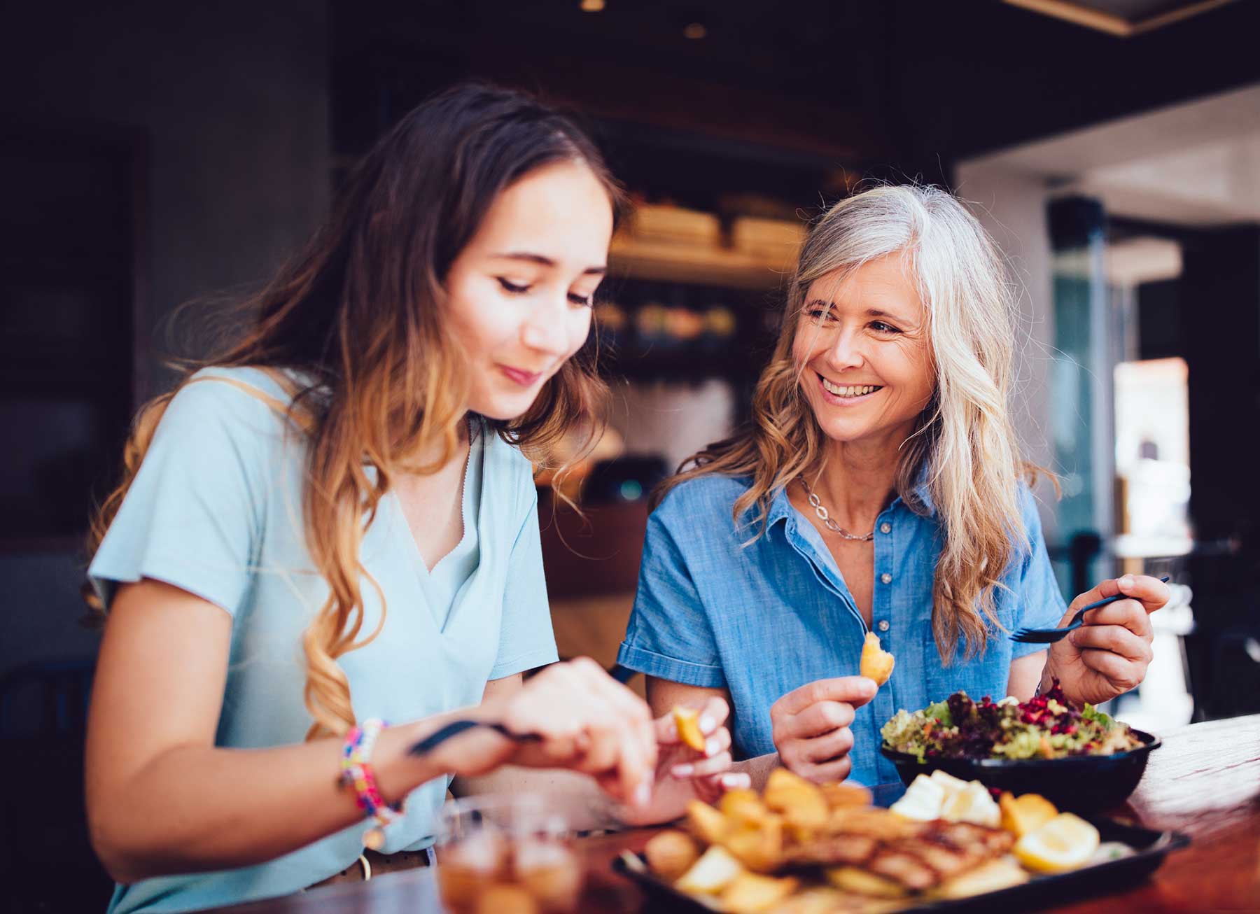 A woman with a hearing aid, talking to her teenage daughter 